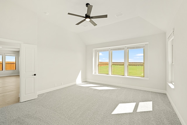 carpeted spare room featuring lofted ceiling and ceiling fan