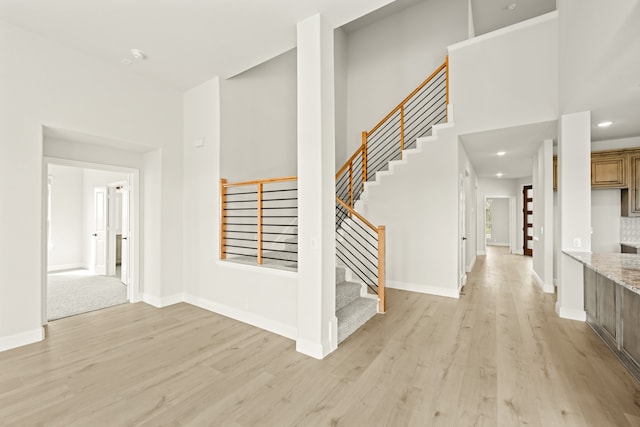 interior space featuring a high ceiling and light wood-type flooring