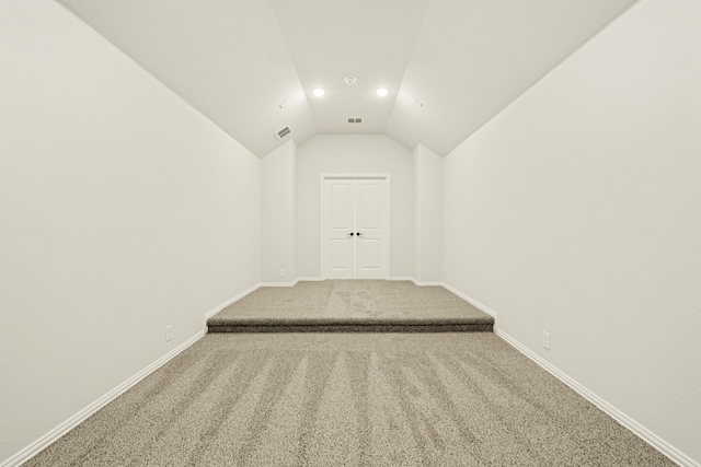 hall featuring vaulted ceiling and carpet flooring