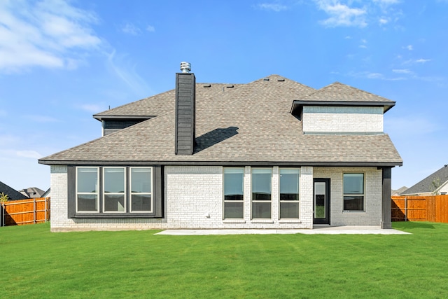 rear view of property with a patio and a lawn