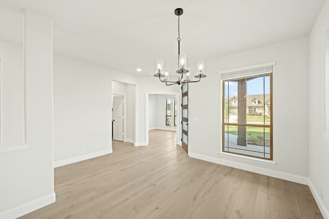 unfurnished dining area featuring a notable chandelier and light wood-type flooring