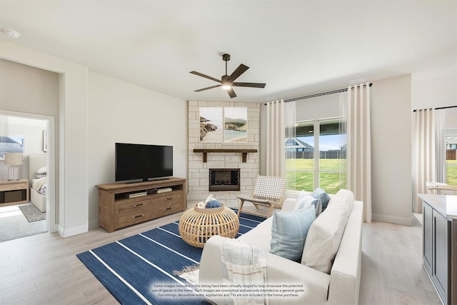 living room with ceiling fan, light wood-type flooring, and a fireplace