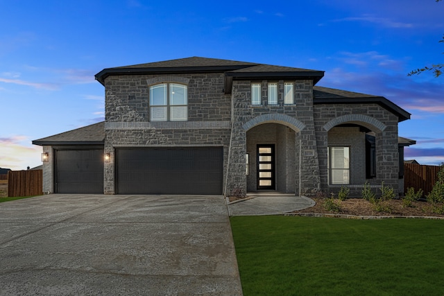 view of front of property featuring a garage and a yard