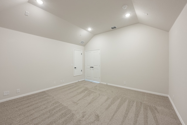 spare room with carpet floors and lofted ceiling