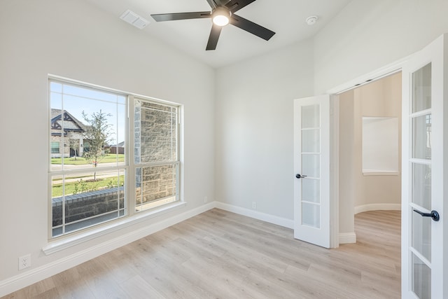 unfurnished room with ceiling fan, light hardwood / wood-style floors, and french doors