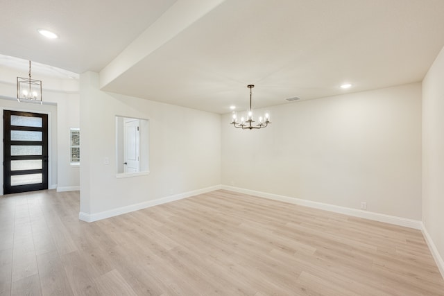 entrance foyer with a notable chandelier and light hardwood / wood-style floors