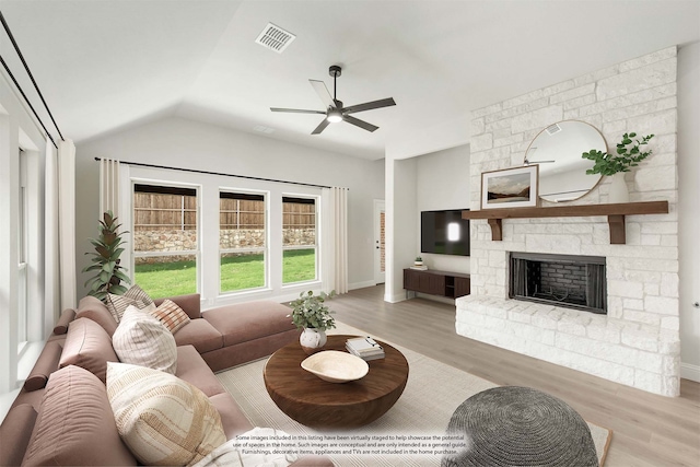 living room featuring ceiling fan, vaulted ceiling, light hardwood / wood-style floors, and a fireplace