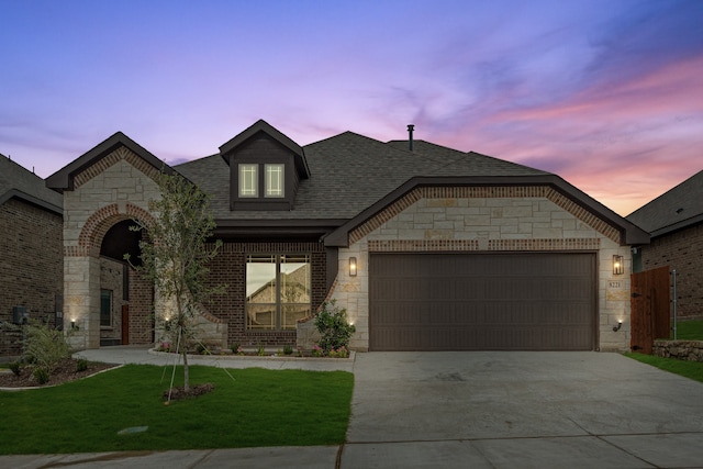 view of front of property with a yard and a garage