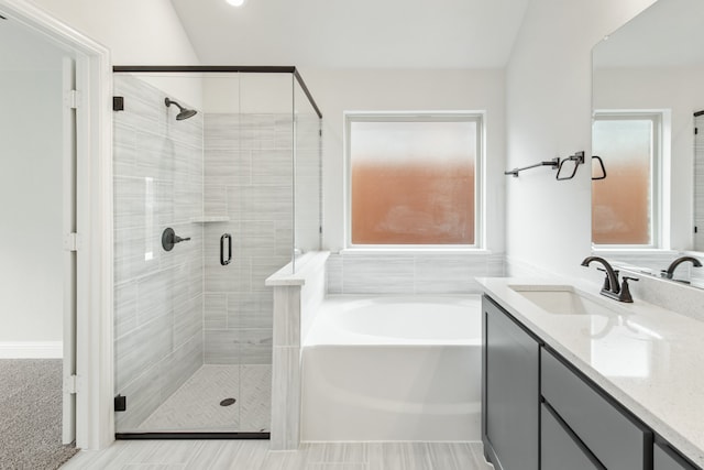 bathroom with plus walk in shower, lofted ceiling, and vanity