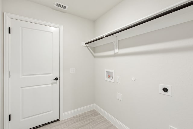 washroom featuring light wood-type flooring, hookup for a gas dryer, electric dryer hookup, and hookup for a washing machine