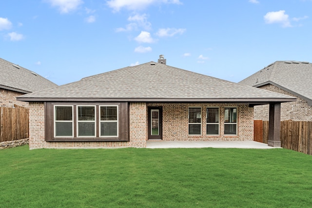 back of house with a lawn and a patio