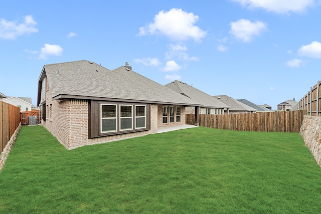 back of house featuring a lawn and a patio area