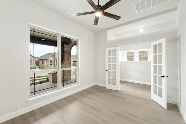 empty room featuring light hardwood / wood-style floors, ceiling fan, and french doors