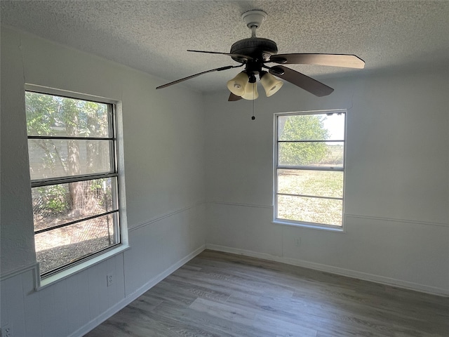 unfurnished room with light wood-type flooring, ceiling fan, and plenty of natural light