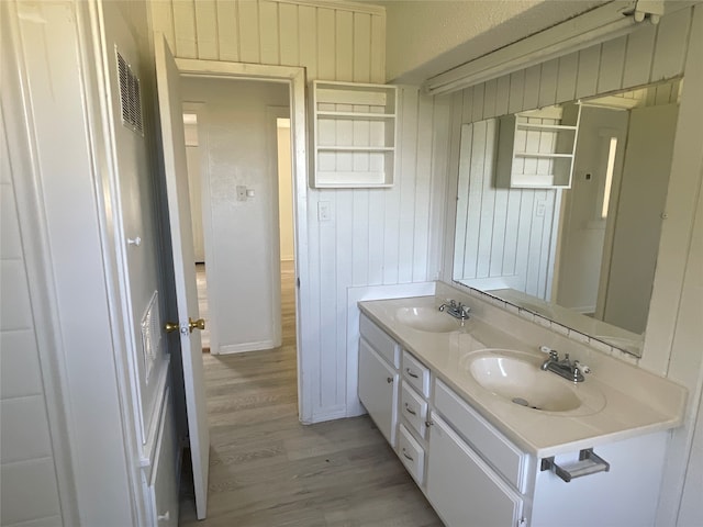 bathroom with wood-type flooring, vanity, and wooden walls