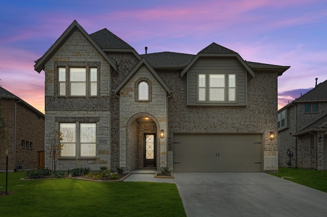 view of front of home featuring a lawn and a garage