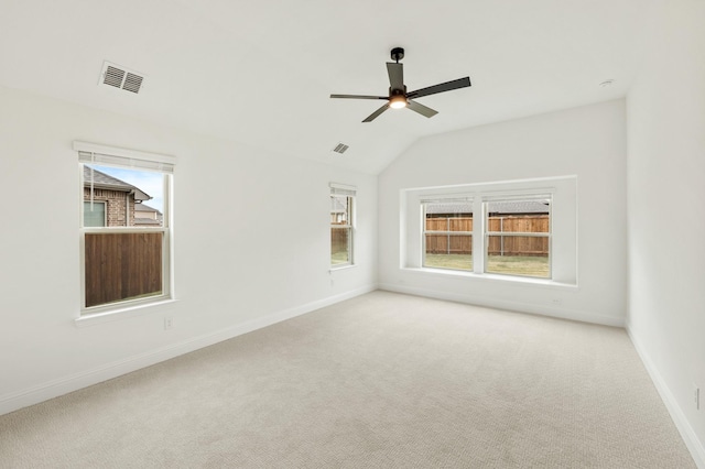 carpeted spare room featuring ceiling fan and vaulted ceiling