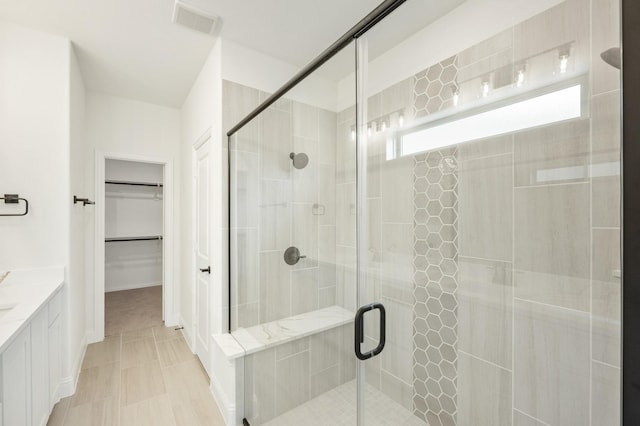 bathroom featuring tile patterned flooring, vanity, and an enclosed shower