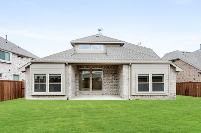 back of house with a patio area and a lawn