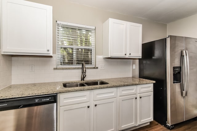 kitchen with dark hardwood / wood-style flooring, backsplash, sink, white cabinets, and appliances with stainless steel finishes