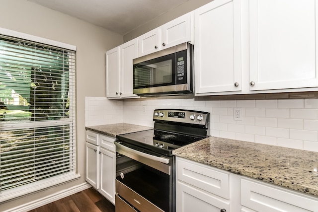 kitchen with stainless steel appliances, dark wood-type flooring, white cabinets, and backsplash