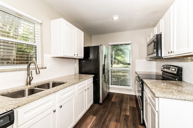 kitchen featuring tasteful backsplash, white cabinetry, dark wood-type flooring, appliances with stainless steel finishes, and sink