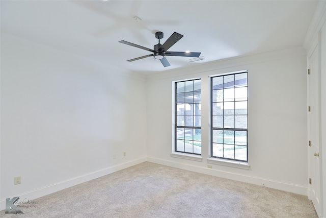 carpeted spare room with ceiling fan and ornamental molding