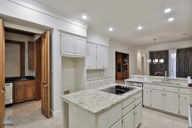 kitchen featuring decorative backsplash, sink, a center island, and black electric stovetop