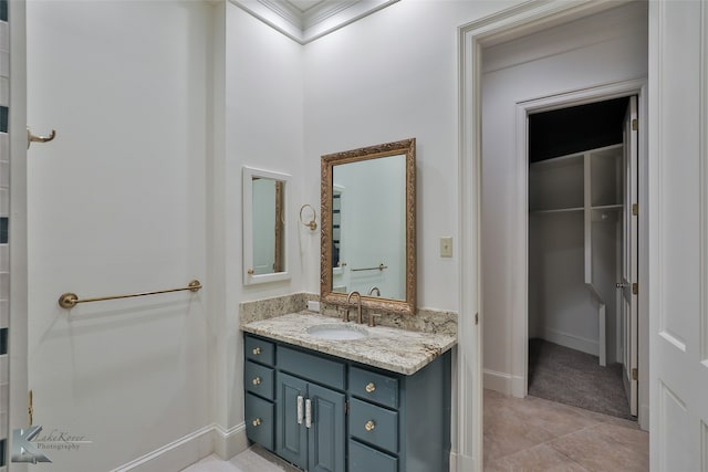 bathroom with ornamental molding, vanity, and tile patterned flooring