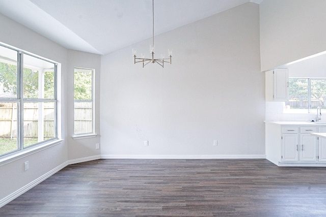 unfurnished dining area featuring a wealth of natural light, dark hardwood / wood-style floors, and vaulted ceiling