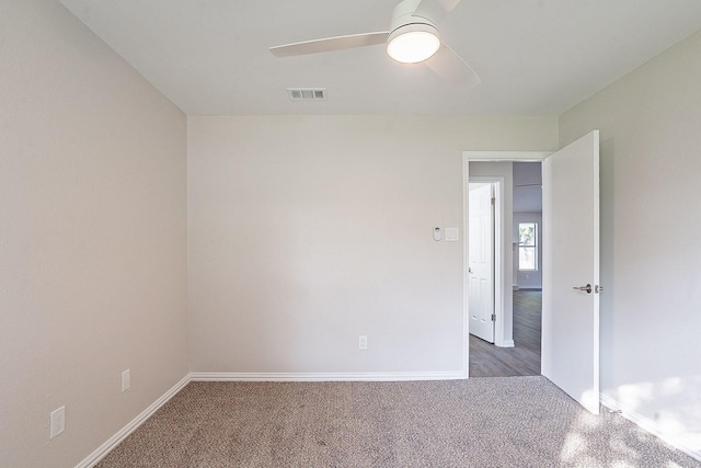 carpeted spare room featuring ceiling fan