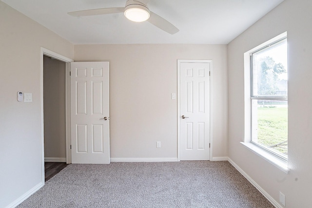 unfurnished bedroom with carpet flooring, ceiling fan, and multiple windows