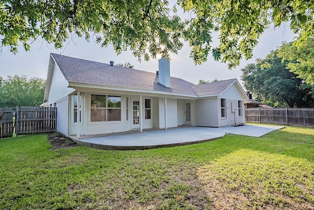 rear view of property featuring a lawn and a patio area