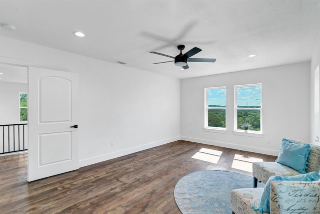 living area with dark hardwood / wood-style flooring and ceiling fan