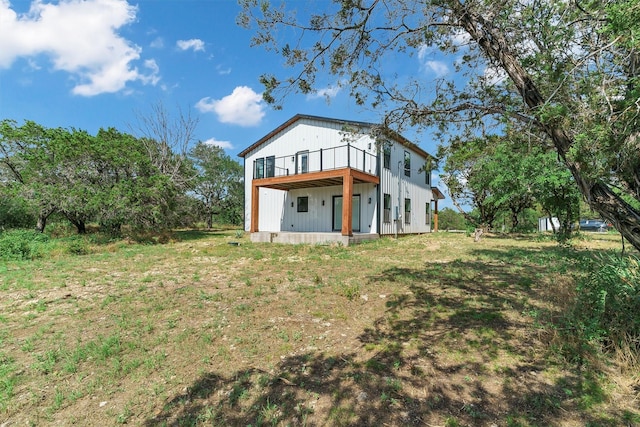 back of property featuring a yard and a balcony