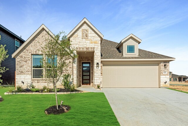 view of front of home with a garage and a front lawn