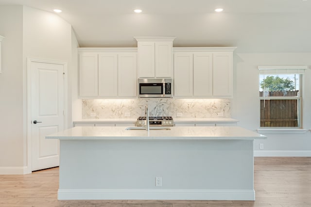 kitchen with light hardwood / wood-style flooring, white cabinetry, and tasteful backsplash