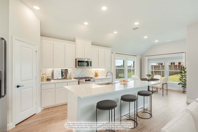 kitchen featuring white cabinetry, appliances with stainless steel finishes, sink, and light wood-type flooring