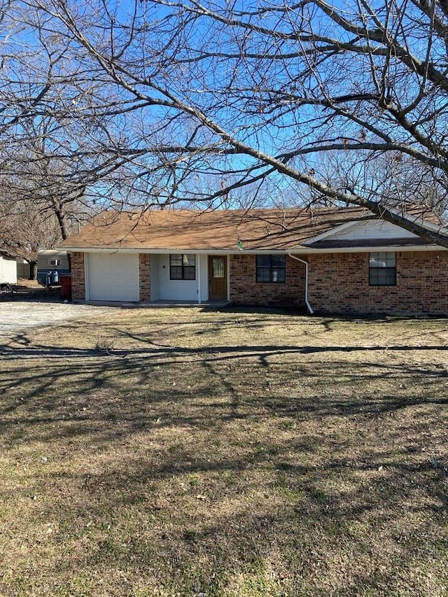 single story home with a garage and a front lawn