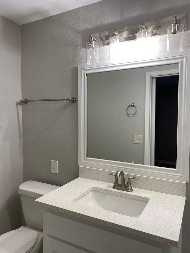 bathroom with vanity with extensive cabinet space and toilet