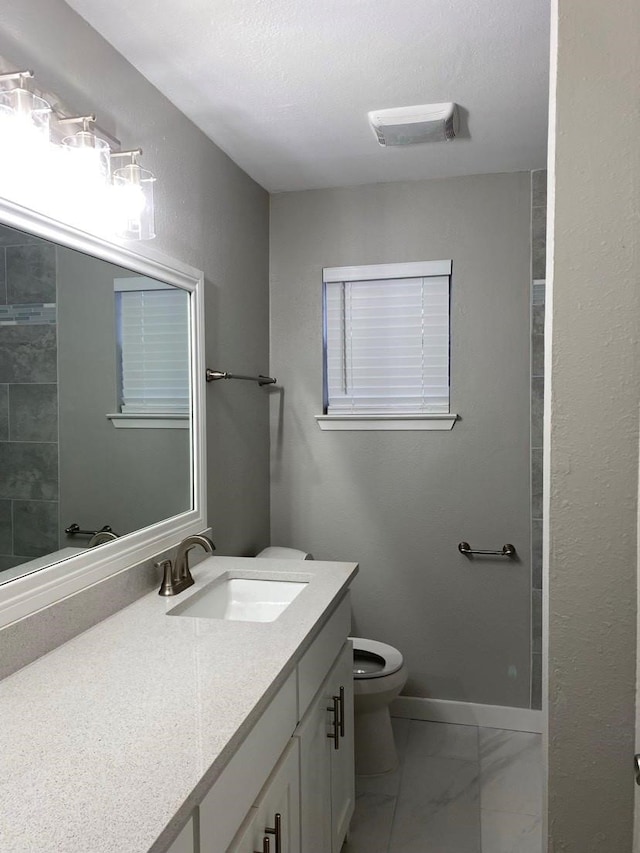 bathroom featuring vanity, toilet, and tile floors