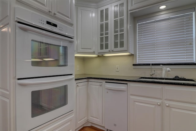 kitchen with glass insert cabinets, white appliances, and white cabinetry