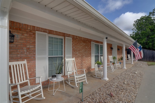 view of patio featuring covered porch and fence