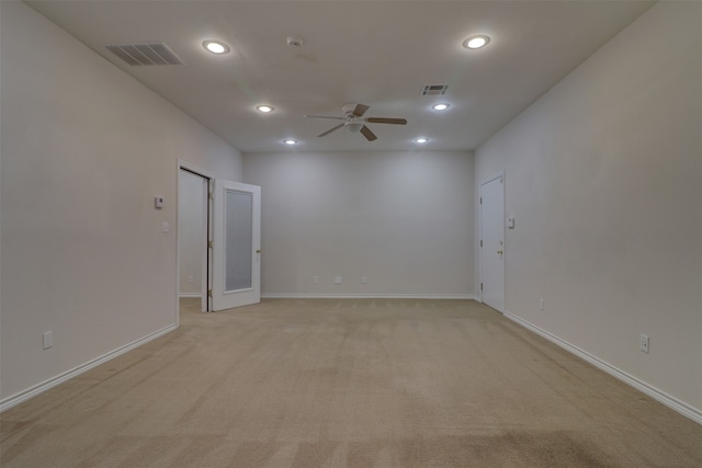 empty room featuring ceiling fan and light colored carpet