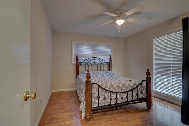 bedroom featuring ceiling fan, baseboards, and wood finished floors