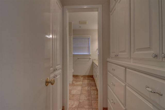 bathroom with toilet, vanity, and baseboards