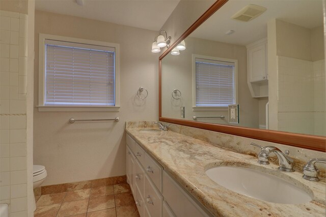 bathroom with tile patterned flooring, vanity, and toilet