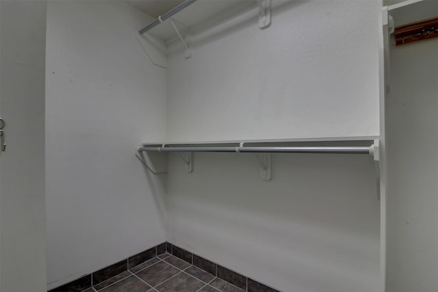 spacious closet featuring dark tile patterned floors