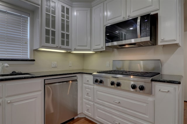 kitchen featuring appliances with stainless steel finishes, light hardwood / wood-style floors, white cabinetry, and sink