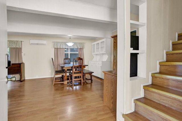 dining room featuring a wall mounted air conditioner and light wood-type flooring